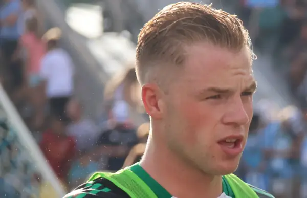 Stephen Welsh. Head shot wearing green bib, 2024.